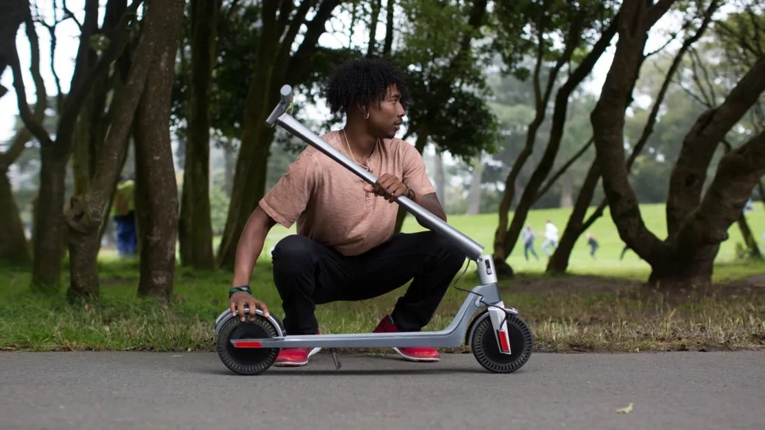 Man folding an electric scooter